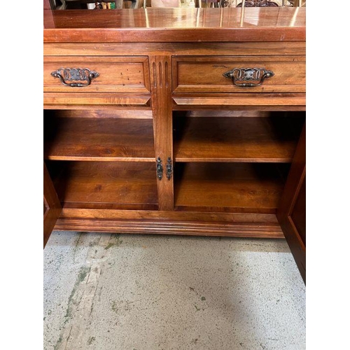 46 - A long hardwood sideboard on bun feet consisting of four drawers and four cupboards with wrought iro... 
