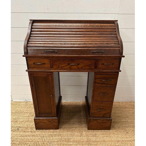 48 - An oak small or child's pedestal roll top desk, six drawers and single cupboards and chair   (H91cm ... 