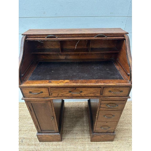 48 - An oak small or child's pedestal roll top desk, six drawers and single cupboards and chair   (H91cm ... 