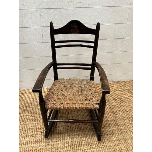 52 - An oak child's rocking chair with reeded seat on inlaid to back