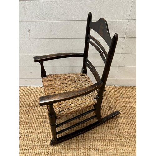52 - An oak child's rocking chair with reeded seat on inlaid to back