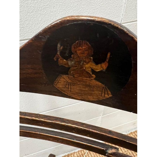 52 - An oak child's rocking chair with reeded seat on inlaid to back