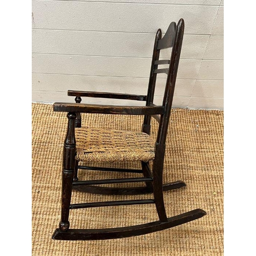 52 - An oak child's rocking chair with reeded seat on inlaid to back