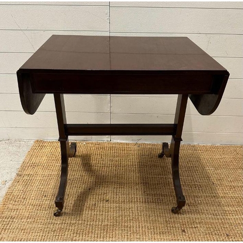7 - A mahogany drop leaf occasional table on splayed legs with castors (H 73cm x D 51cm x W108cm)