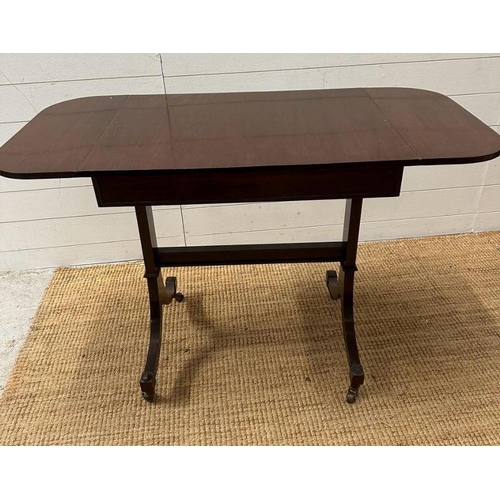 7 - A mahogany drop leaf occasional table on splayed legs with castors (H 73cm x D 51cm x W108cm)