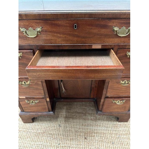 8 - An oak kneehole desk with centre cupboard flanked by three drawers to left and right with brass drop... 