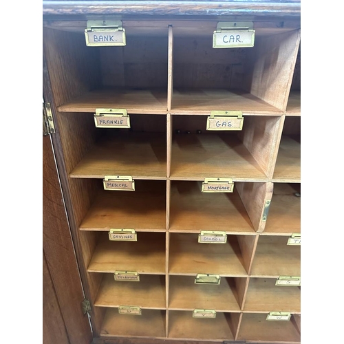 1 - An oak postmaster pigeon hole sorting cupboard made up of twenty four sorting departments (H66cm D26... 