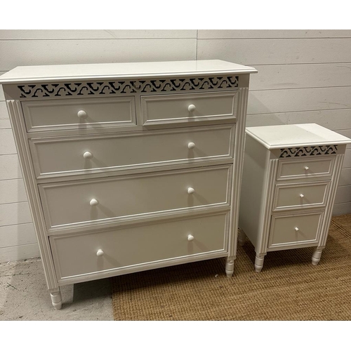 110 - A white painted two over three chest of drawers and matching bedside table