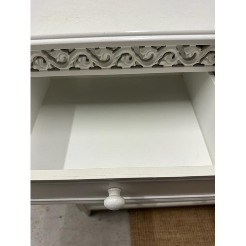 110 - A white painted two over three chest of drawers and matching bedside table