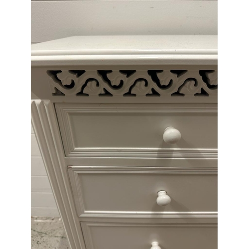 110 - A white painted two over three chest of drawers and matching bedside table