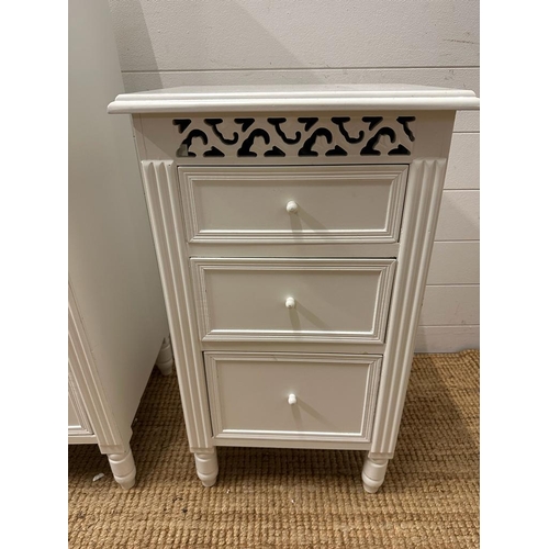 110 - A white painted two over three chest of drawers and matching bedside table