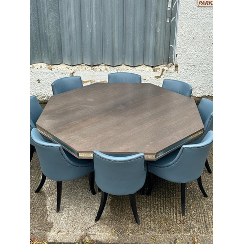 115 - A contemporary  octagonal dining table and ten grey/blue upholstered chairs Diameter194cm