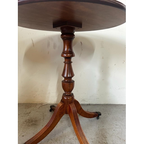 116 - A mahogany circular side table with string inlaid on lion paw feet and castors (H65cm Dia54cm)