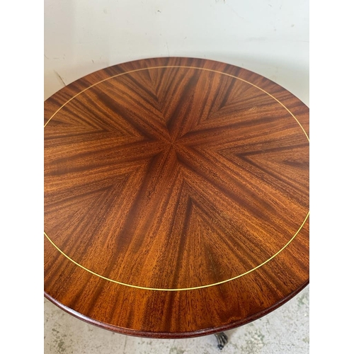 116 - A mahogany circular side table with string inlaid on lion paw feet and castors (H65cm Dia54cm)