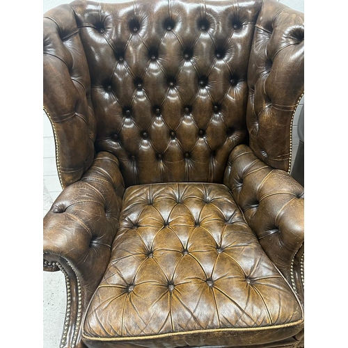 130 - A pair of brown leather Chesterfield style wing back arm chairs (H107cm D68cm)