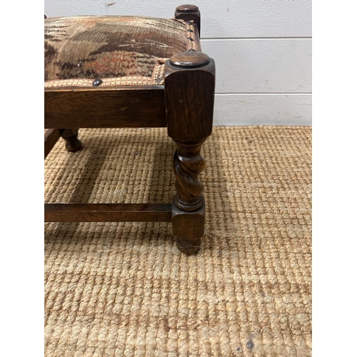 136 - An oak upholstered foot stool on barley twist supports (H30cm)