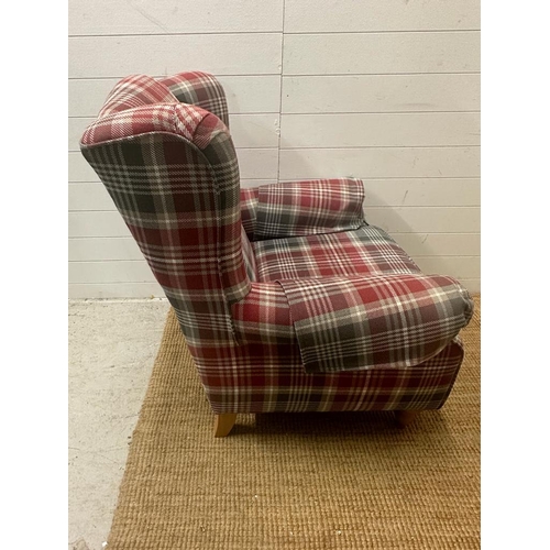 14 - A check upholstered wing back arm chair and matching foot stool