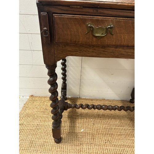 148 - An oak bureau on barley twist support and cross stretcher with single drawer and brass drop handles ... 