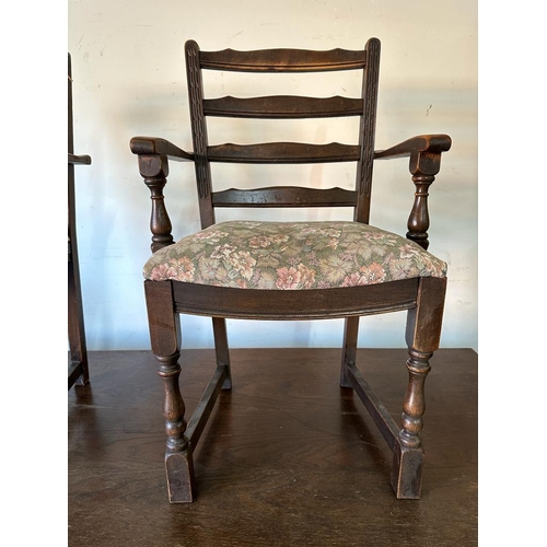 156 - An oak Arts and Crafts style extending dining table on carved supports and cross stretcher  with two... 