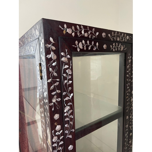 162 - A hardwood, double side opening Chinese display cabinet with mother of pearl inlay and three glass s... 