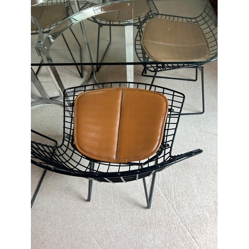 167 - A set of eight Harry Bertoia chairs with brown leather seat pads and a Merrow Associates glass table... 