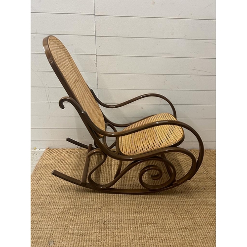 17 - A Bentwood and cane seated rocking chair with scrolling arms