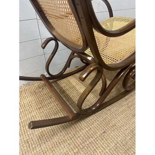 17 - A Bentwood and cane seated rocking chair with scrolling arms