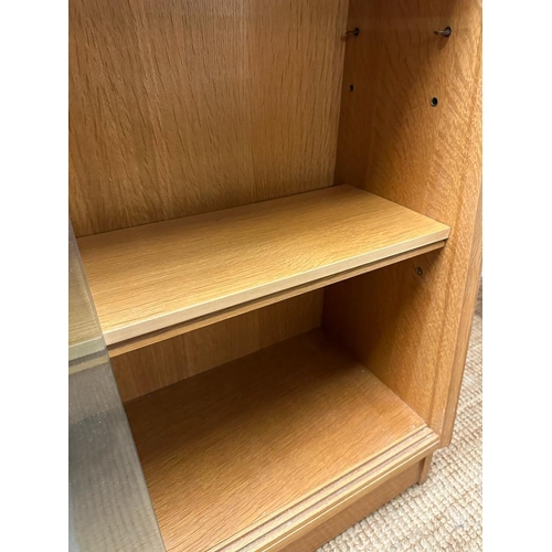 184 - A light oak Mid Century two shelf bookcase with glazed sliding doors (H85cm W91cm D30cm)