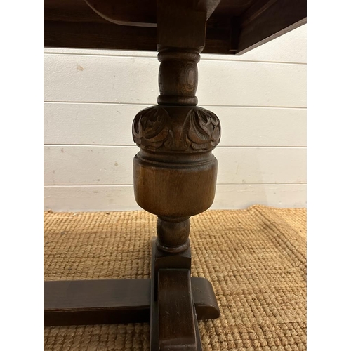 192 - A Mid Century oak coffee table on carved supports with cross stretches (H55cm W133cm D57cm)