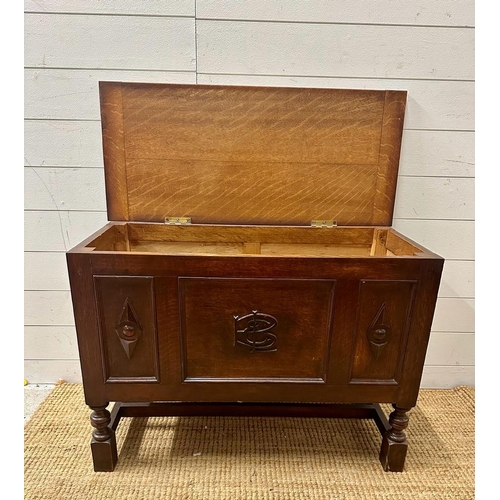 225 - A small panelled oak coffer with detailing to front (H60cm W37cm D83cm)