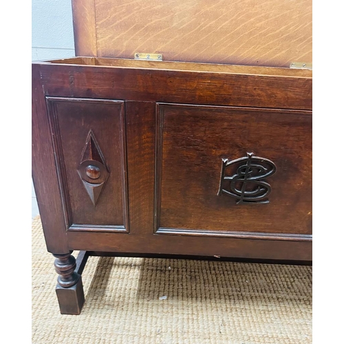 225 - A small panelled oak coffer with detailing to front (H60cm W37cm D83cm)