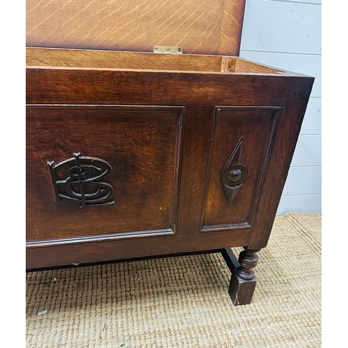 225 - A small panelled oak coffer with detailing to front (H60cm W37cm D83cm)