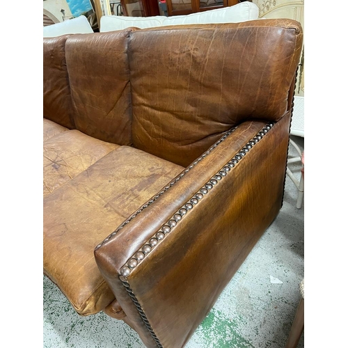 232 - A three seater leather sofa with stud detail to base