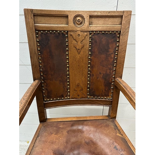 264 - An oak carved leather seated arm chair on turned supports and legs