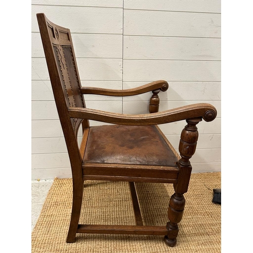 264 - An oak carved leather seated arm chair on turned supports and legs