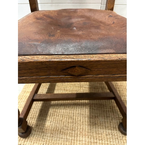 264 - An oak carved leather seated arm chair on turned supports and legs