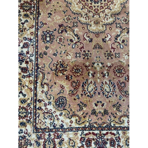 267 - A pink ground pray mat or rug with floral border (126cm x 58cm)