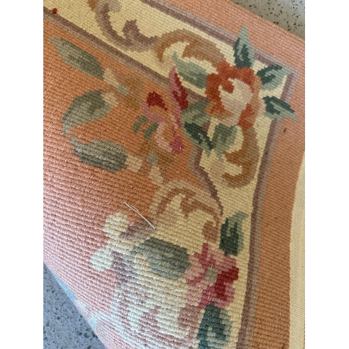 268 - A pink ground rug with central floral motif (126cm x 58cm)