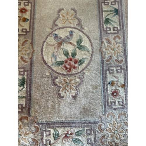 269 - A grey rug with central motif and border (106cm X 60cm)