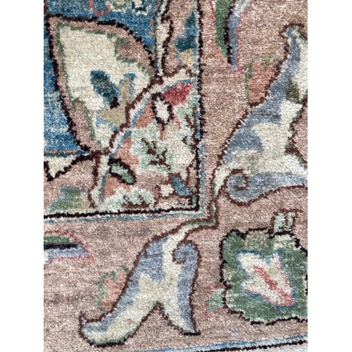 271 - A beige ground rug with floral pattern and geometric boarder *97cm x 152cm)