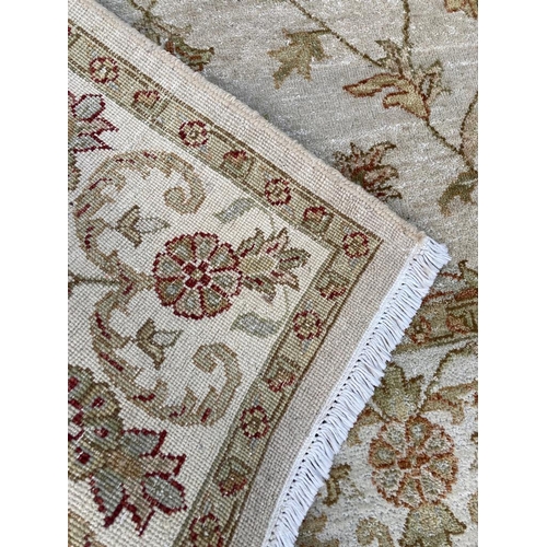 273 - A beige ground rug with floral pattern and geometric boarder (120cm x 190cm)