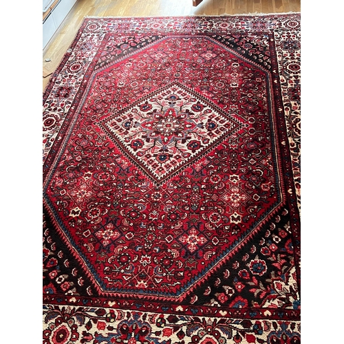 274 - A red ground hand knotted wool carpet (3.45 m x 2.10 m)