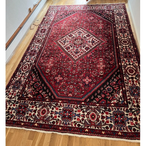 274 - A red ground hand knotted wool carpet (3.45 m x 2.10 m)