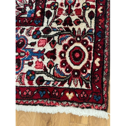 274 - A red ground hand knotted wool carpet (3.45 m x 2.10 m)