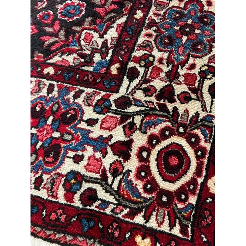 274 - A red ground hand knotted wool carpet (3.45 m x 2.10 m)