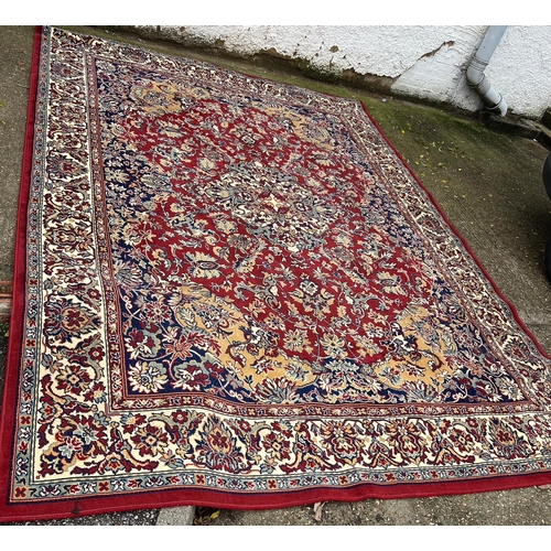 275 - A large red ground rug with geometric pattern 296cm x 396cm