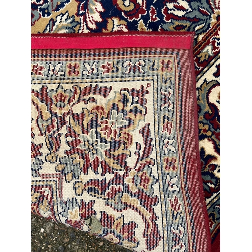 275 - A large red ground rug with geometric pattern 296cm x 396cm