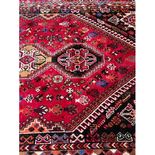 276 - A hand knotted red ground carpet/rug with geometric pattern 204cm x 295cm