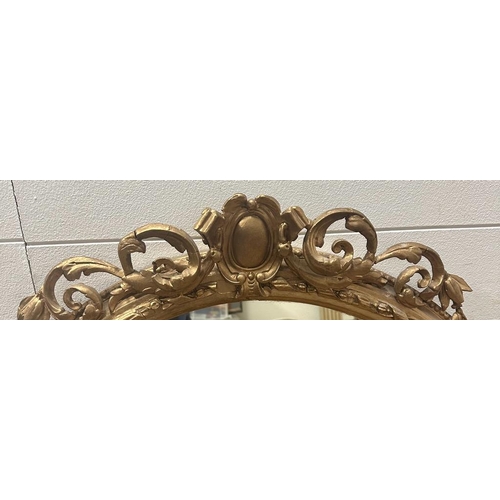 279 - A large gilt framed oval over mantel mirror in Coco style AF (H117cm W121cm)