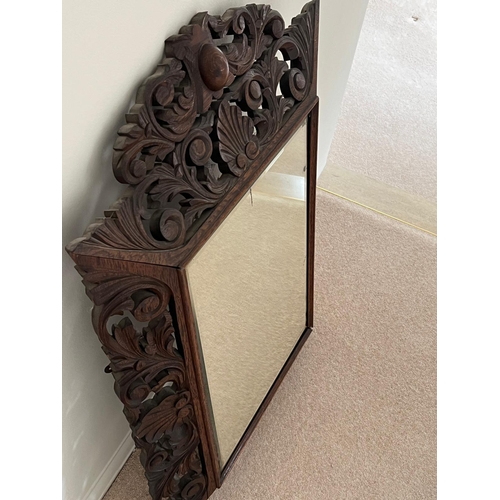 284 - An ormate Oriental hardwood mirror with foliate frame (80cm H x 65cm W